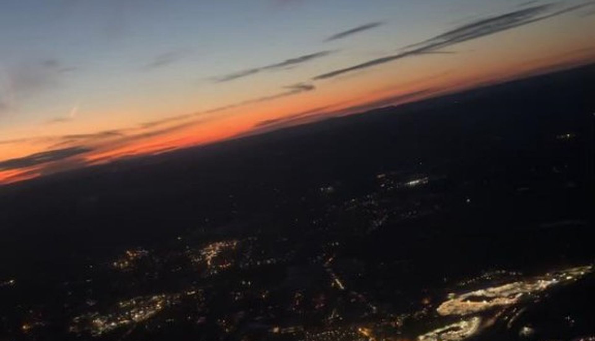 Aerial view of city lights at dusk from an aircraft